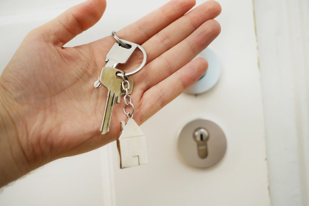 Landlord handing over house keys after selling a rental property as-is in NY