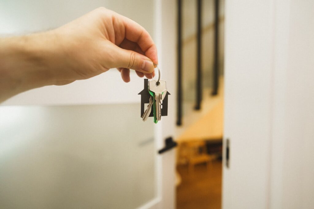 Landlord handing over keys after selling a rental with tenants in place