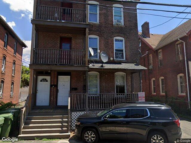 A brick three family with stacked porches on Babcock Street in Frog Hollow, Hartford