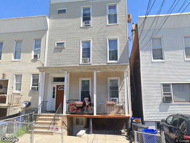 A frame three family with a full front porch on Hutton Street in the Heights
