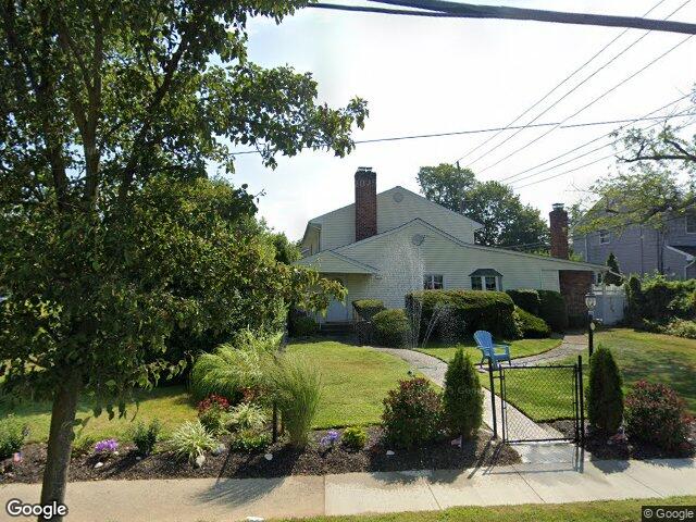 A well kept cape with mature landscaping on a quiet Wantagh street